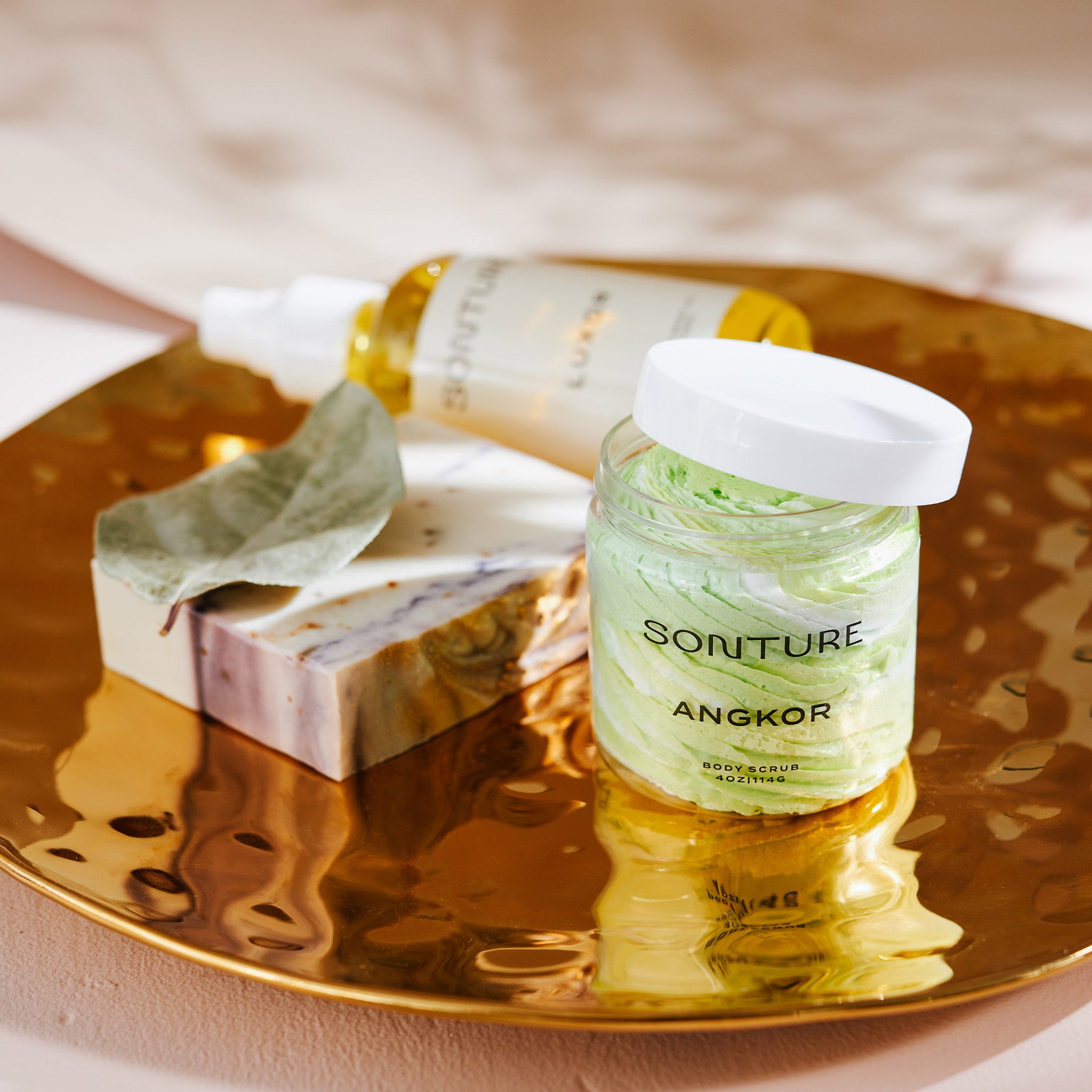 A collection of Sonture’s handmade, ethically created body care products inspired by travel. The products are styled on a gold tray and look high end, Luxurious and perfect for glamorous bathrooms.